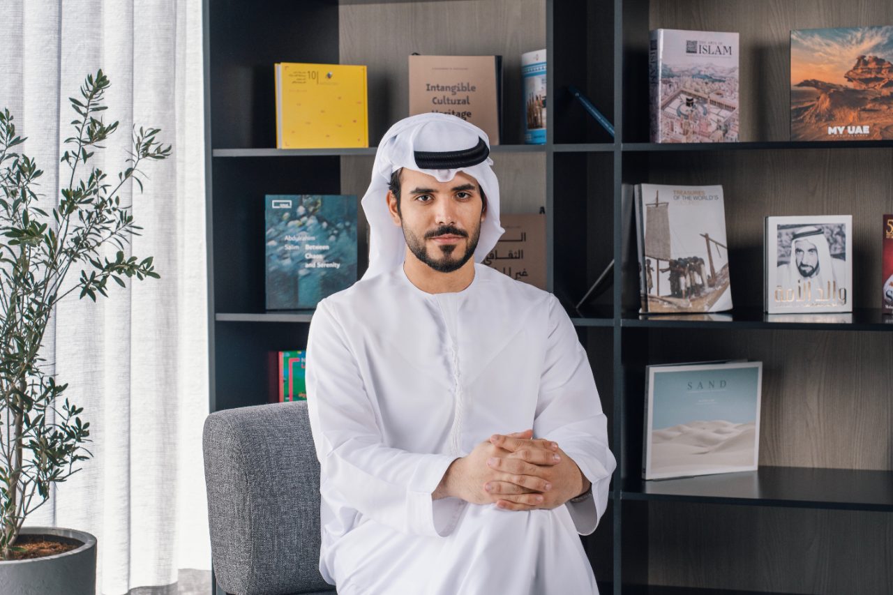 Founder portrait — Tahnoon Alqubaisi reviewing material samples on a stone table by the water at dusk.